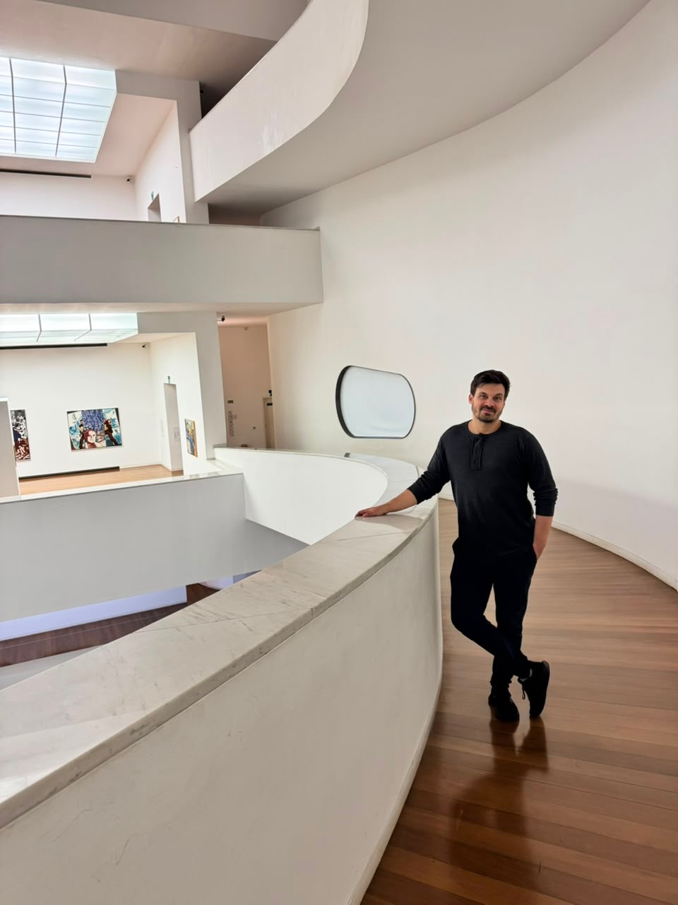 Dr. Bruno Goldani, de preto, em um museu de arte de arquitetura modernista.